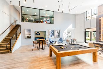 A game room with a pool table and a staircase